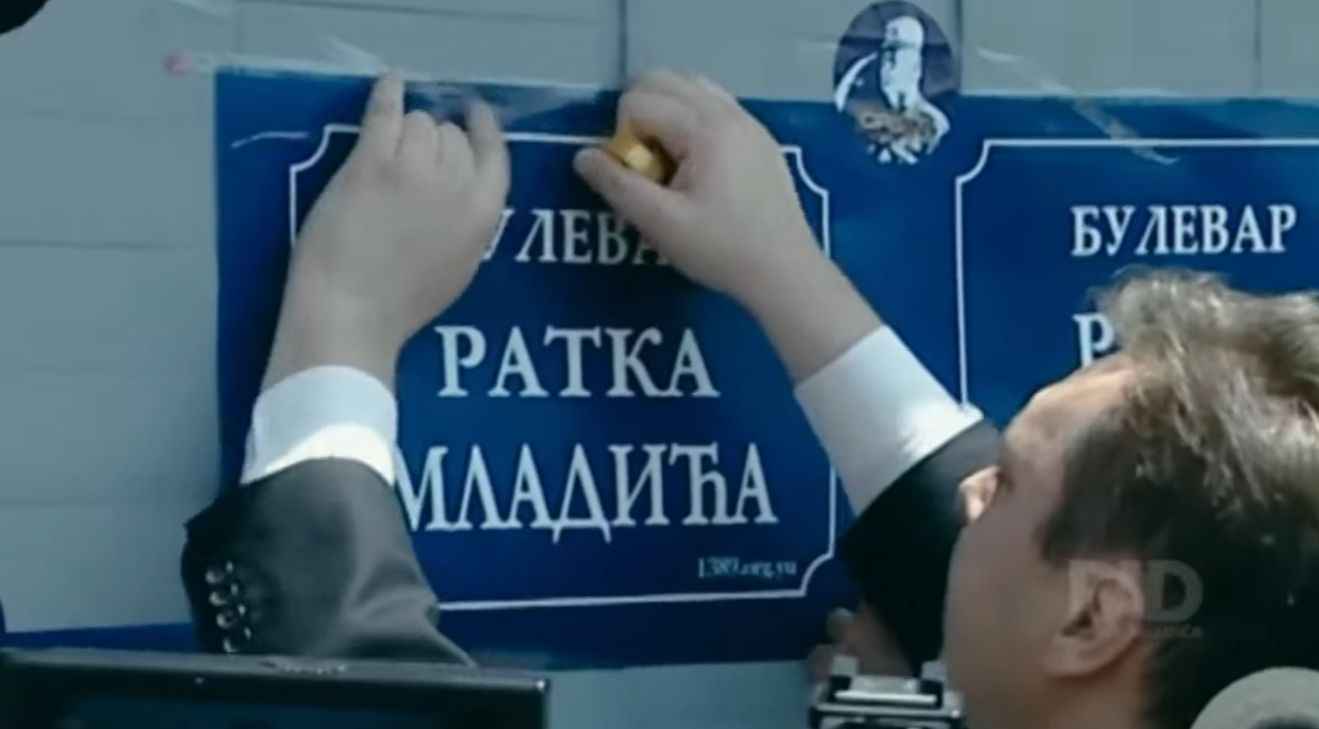 Aleksandar Vučić lepi plakat sa natpisom 
